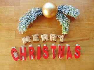 Merry christmas written with cookies and in red with decoration above