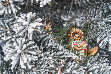 Christmas toy owl on snow-covered fir-tree