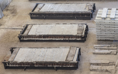 Stack of precast reinforced concrete slabs in a house-building factory workshop