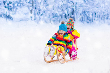 Kids play in snow. Winter sleigh ride for children