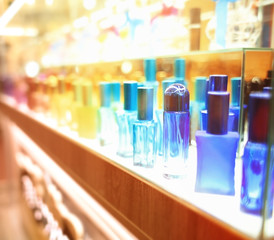 Stand with colourful glass bottles in cosmetic store