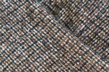 Fototapeta premium Wool or Tweed texture background. Fabric checkered in brown. Selective focus.