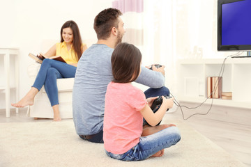Happy family playing video games at home © Africa Studio