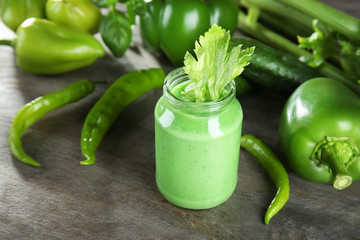 Glass jar with vegetable smoothie on wooden table