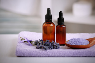 Bottles with lavender essential oil on towel, closeup