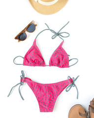 Summer outfit, beach outfit, summer stuff. Pink polka dot swimsuit, retro sunglasses, straw hat. Flat lay, top view