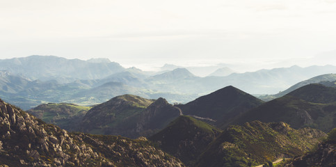 Green valley on background sky and clouds. Panorama  horizon view of scenery  foggy hills Northern Spain alps. Travel mockup concept in morning time. Sunset in the mountain natural landscape