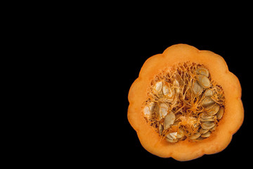 Half mini pumpkin on black background with copy space