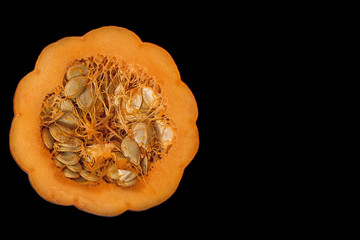 Half mini pumpkin on black background with copy space