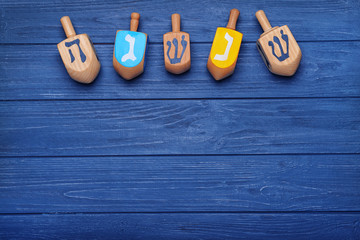 Dreidels for Hanukkah on blue wooden table © Africa Studio