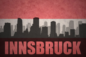 abstract silhouette of the city with text Innsbruck at the vintage austrian flag