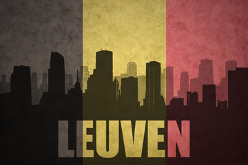 abstract silhouette of the city with text Leuven at the vintage belgian flag