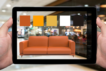 Augmented reality marketing technology for access entire product inventory in-store concept. Hand holding tablet use AR application for simulate furniture and colour in retail store. 3D rendering