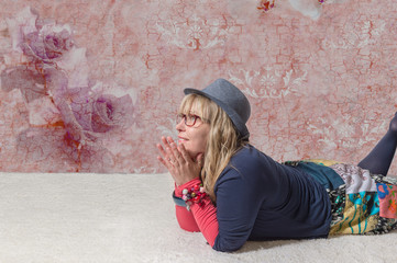 Blonde Frau mit Hut blickt staunend