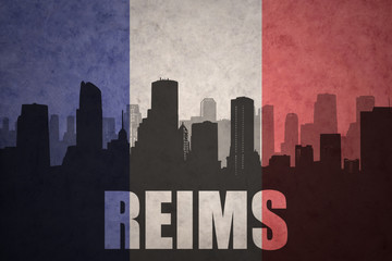 abstract silhouette of the city with text Reims at the vintage french flag