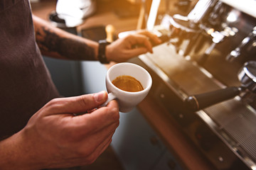 cup with hot cappuccino in man hands