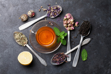 Tea cup and assortment of dry tea in spoons