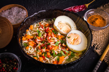 Noodles with egg and spices on a dark background