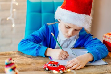 Child writing a letter to Santa Claus at home.