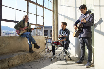 Ready for entertain. Full length shot of a rock band practicing to playing music.
