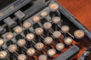 Close-up of a dark and rusty vintage typewriter.
