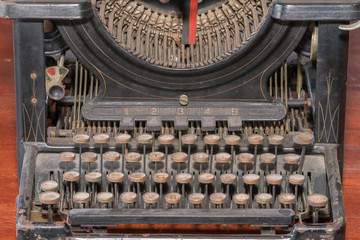 Antique typewriter in vintage and grunge looks on a wooden table.
