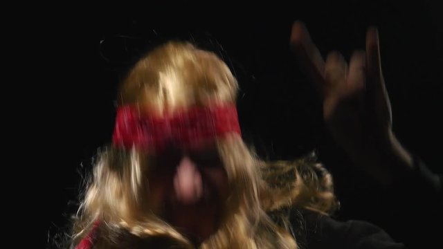 Metal head looking funny headbanging and looking funny. Black background