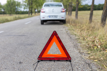  red triangle to warn the other road users about a damaged car