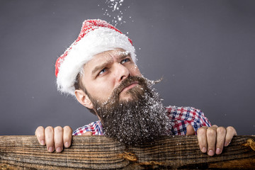 Closeup portrait of a sad bearded man with santa cap looking up. - obrazy, fototapety, plakaty