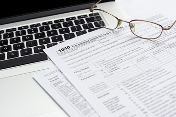 U.S. 1040 income tax return form with laptop and glasses