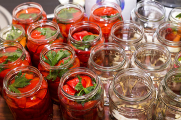 Fototapeta na wymiar pickled red sweet peppers in glass jars