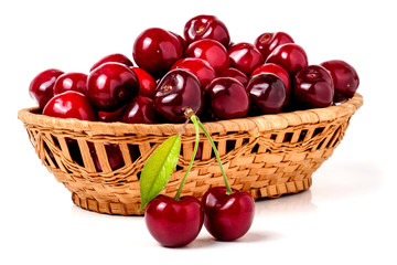 cherries in a wicker basket isolated on white background