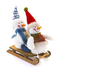 Two Snowman on a sledge on a white background.