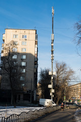 Cellular antenna on the street in the city among the houses