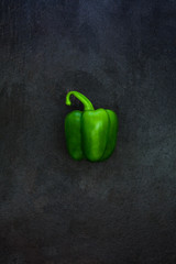 Green bell pepper isolated on rustic gray slate stone background