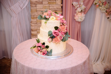 Sweet multilevel wedding cake decorated with beautiful flowers. Candy bar