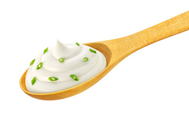 Sour cream in wooden spoon isolated on white background