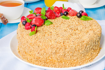 Homemade honey cake with sour cream and berries on top