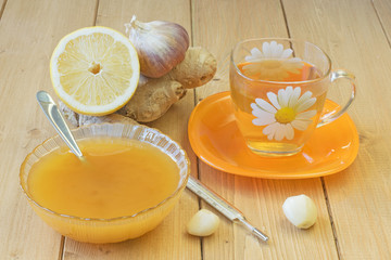 The root of ginger and honey on wooden table.