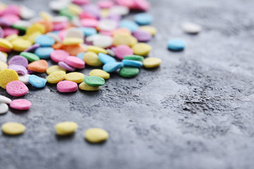 Colorful sprinkles on a grey wooden table