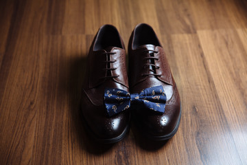 Groom accessories, bow-tie, shoes on the table. Concept of gentleman dress