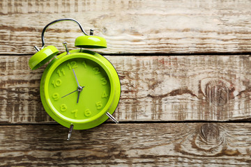 Green alarm clock on a grey wooden table