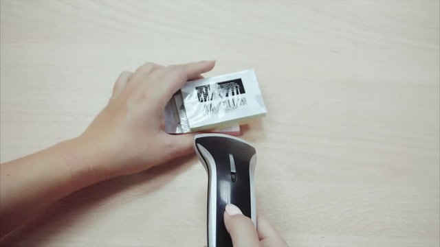 Woman seller hands using barcode scanner goods wooden table background 4K