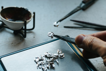 Jewelry tools. Jewellery. Goldsmith workplace, workspace on light background. Hand craft. Workshop. Manufacturing. Weigh-scales with granules of metal silver and platinum. Closeup. Toned