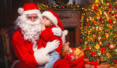 Fototapeta na wymiar happy child girl hugging Santa