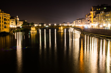 Ponte alle Grazie bridge at night with light reflection on the Arno River, Florence