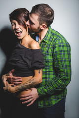 Beautiful couple hugging and laughing on the tein background. The concept of fun, love and happiness