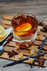 Hot tea in a glass with spices on a wooden background. Selective focus.Still life, food and drink, seasonal and holidays concept
