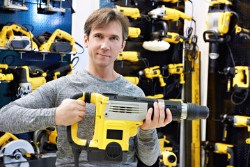 Man with hammer drill in hardware store