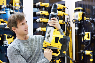 Man with hammer drill in hardware store